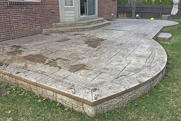 Stained stamped concrete patio in St. Thomas before sealing